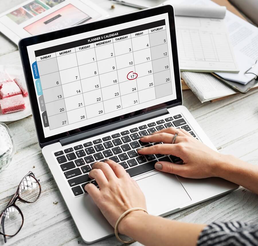 Foto de persona verificando el calendario de su computadora